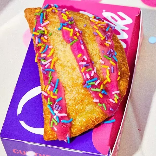 Taco Bell Milk Bar Birthday Cake Empanada with pink frosting and rainbow sprinkles