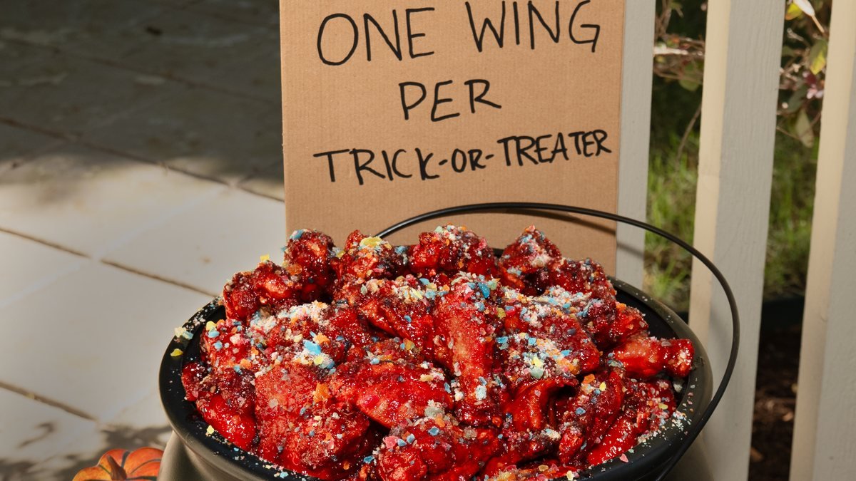 Wingstop Sour Patch Kids Wicked Punch wings in a cauldron with a One Wing Per Trick-or-Treater sign